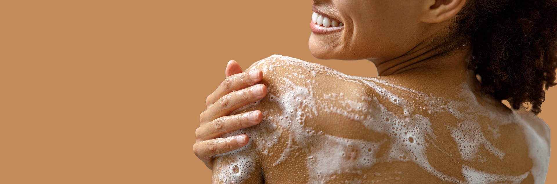 Smiling woman applying shower gel